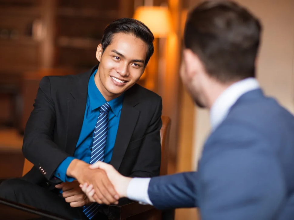 Two men shaking hands in a restaurant.